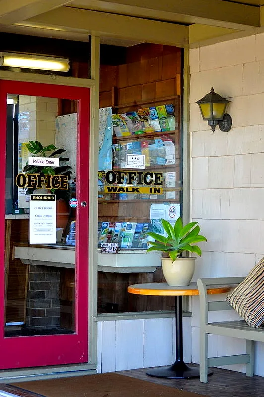 Mayfield Motel’s reception entrance — a red-framed glass door with gold OFFICE lettering.