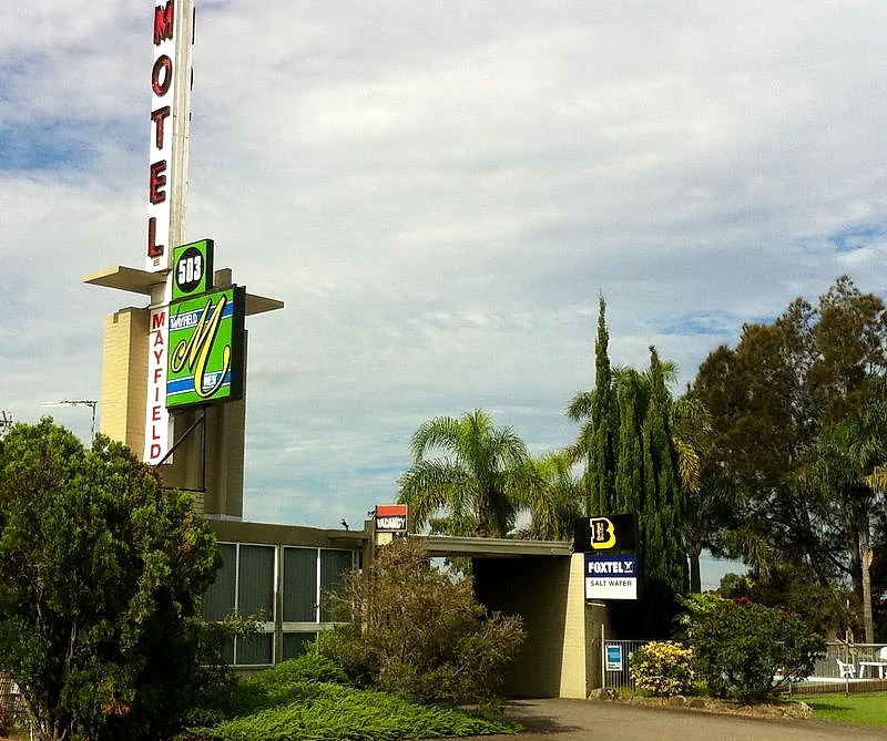 Mayfield Motel’s original pylon sign and mid-century entrance canopy in daylight, seen from the driveway on Maitland Road.